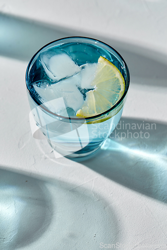 Image of blue glass of water with lemon and ice