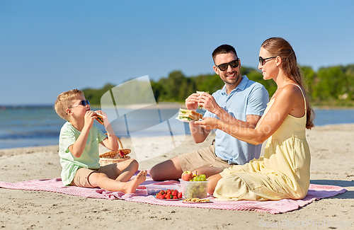 Image of happy family having picnic on summer beach