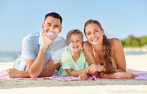 Image of happy family lying on summer beach