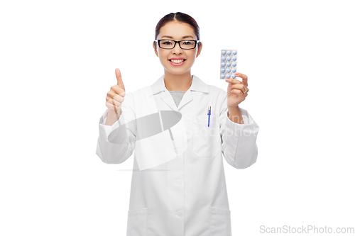 Image of smiling asian female doctor or nurse with medicine