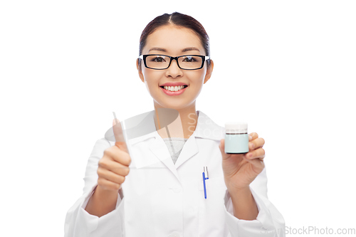 Image of smiling asian female doctor or nurse with medicine