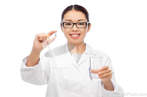 Image of asian doctor with medicine and glass of water