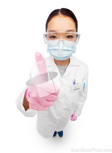 Image of asian female doctor in mask showing thumbs up
