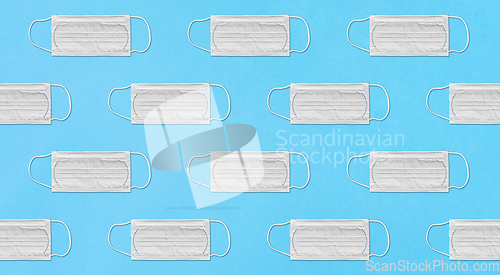 Image of white medical mask pattern on blue background