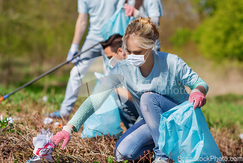 Image of volunteers with garbage bags cleaning park area