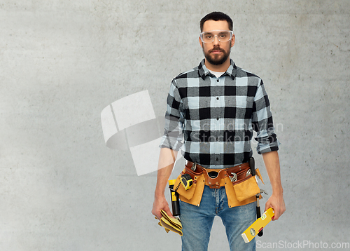 Image of male worker or builder with tools and level