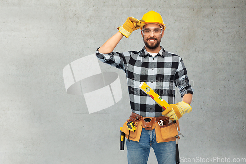 Image of happy male worker or builder in helmet with level