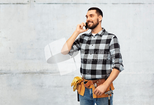 Image of builder in helmet calling on smartphone