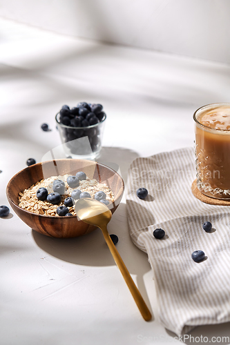 Image of oatmeal with blueberries, spoon and coffee