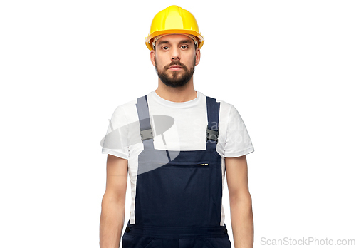 Image of male worker or builder in helmet and overall