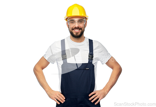 Image of happy male worker or builder in helmet and overall