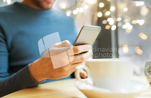 Image of close up of man with smartphones at cafe