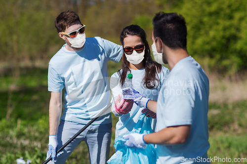 Image of volunteers with garbage bags cleaning park area