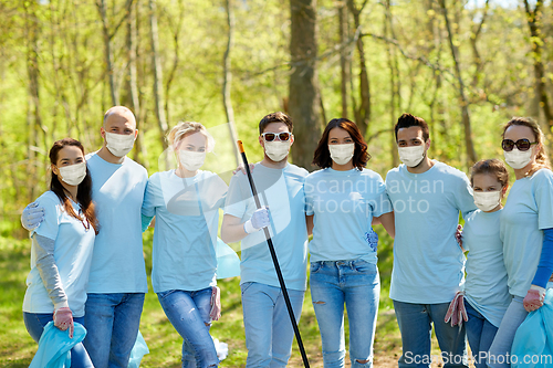 Image of volunteers in masks with garbage bags at park