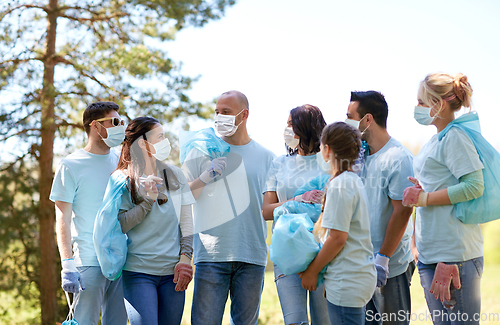 Image of volunteers in masks with garbage bags talking