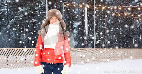 Image of happy woman in winter fur hat at ice rink