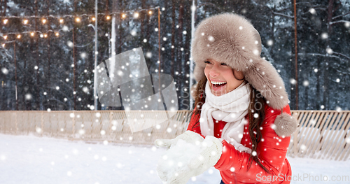 Image of happy woman with snow in winter hat at ice rink