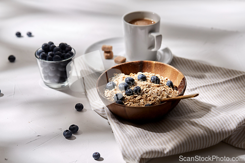 Image of oatmeal with blueberries, spoon and cup of coffee