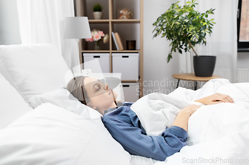 Image of young woman sleeping in bed at home