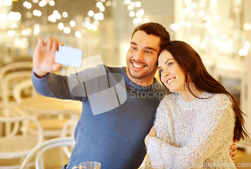 Image of couple taking smartphone selfie at cafe restaurant