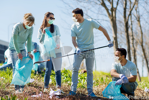 Image of volunteers with garbage bags cleaning park area