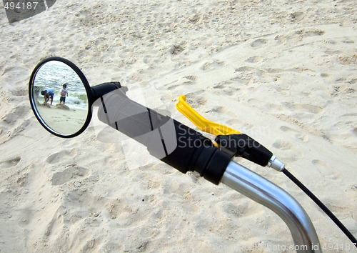 Image of kids on the beach through the bike mirror
