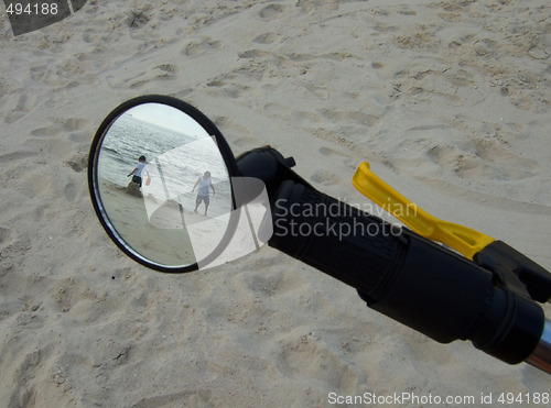 Image of kids on the beach through the bike mirror