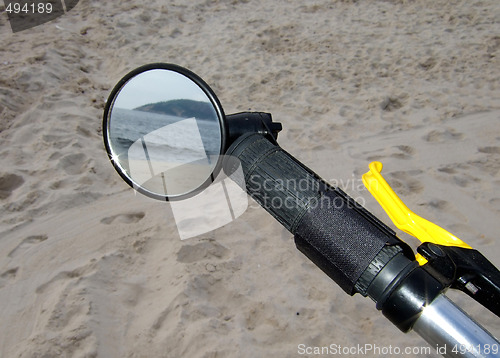 Image of beach through the bike mirror