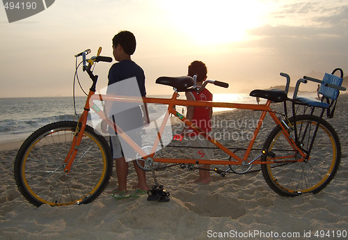 Image of double bike on the beach sand