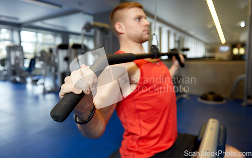 Image of close up of man exercising on cable machine in gym