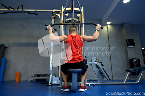 Image of close up of man exercising on cable machine in gym