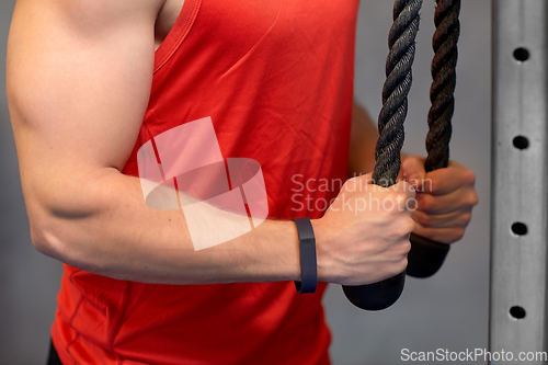 Image of close up of man exercising on cable machine in gym