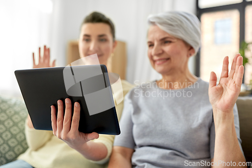 Image of daughter and mother having video call on tablet pc