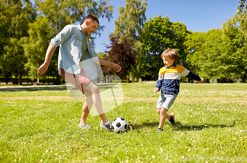 Image of father with little son playing soccer at park