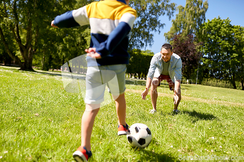 Image of father with little son playing soccer at park