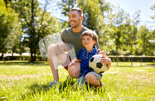 Image of father and little son with soccer ball at park