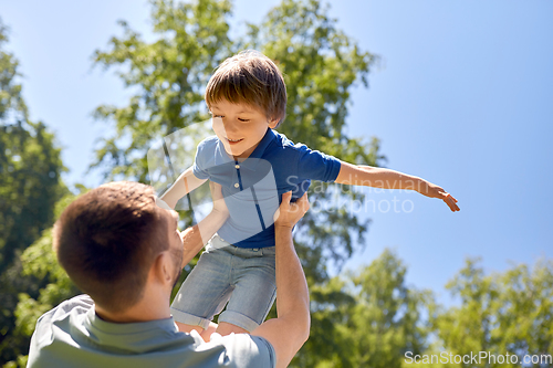 Image of happy father with son playing in summer park