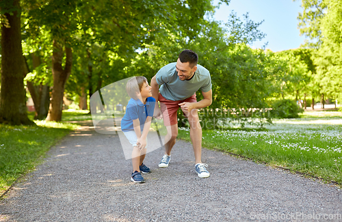 Image of happy father and son compete in running at park