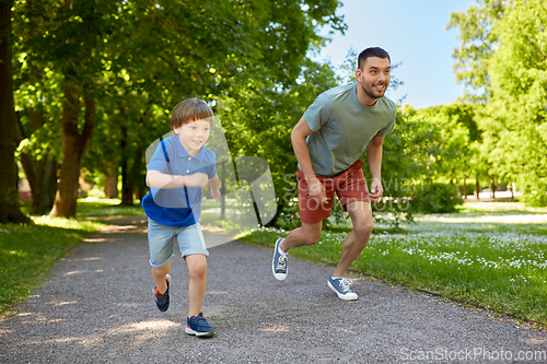 Image of happy father and son compete in running at park