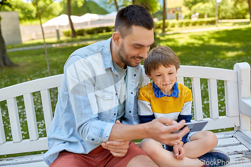Image of father and son with smartphone at park