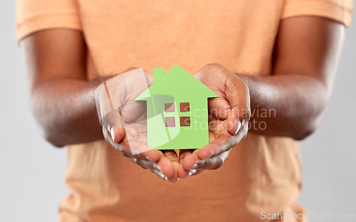 Image of close up of african man holding green house