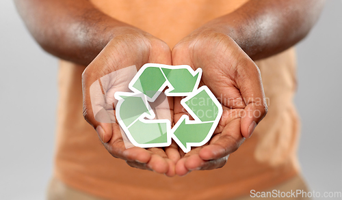 Image of close up of man holding green recycling sign