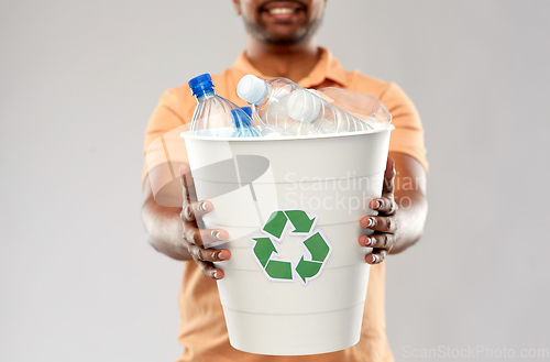 Image of close up of young indian man sorting plastic waste