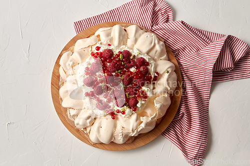 Image of pavlova meringue cake with berries on wooden board