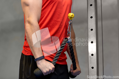 Image of close up of man exercising on cable machine in gym