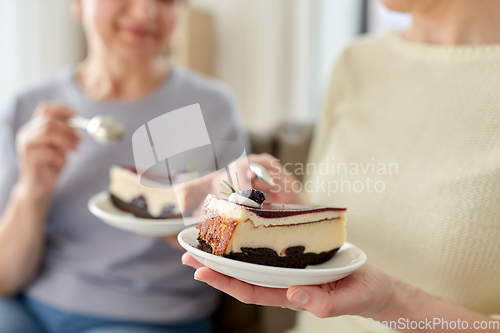 Image of close up of women eating cake at home