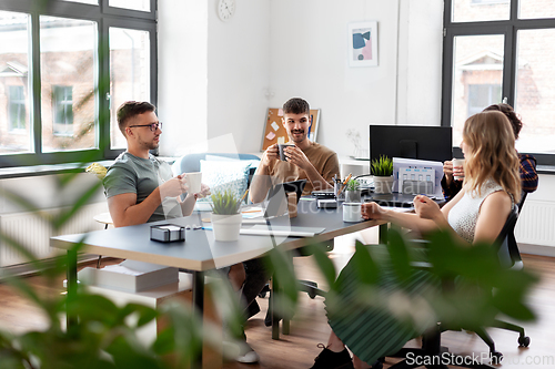 Image of team of startuppers drinking coffee at office