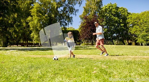 Image of father with little son playing soccer at park