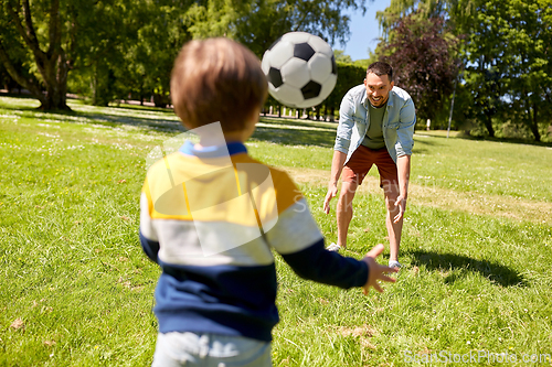 Image of father with little son playing soccer at park