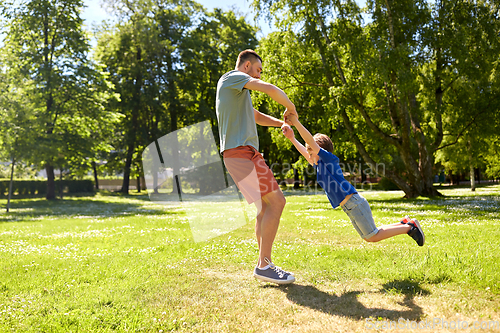 Image of happy father with son playing in summer park